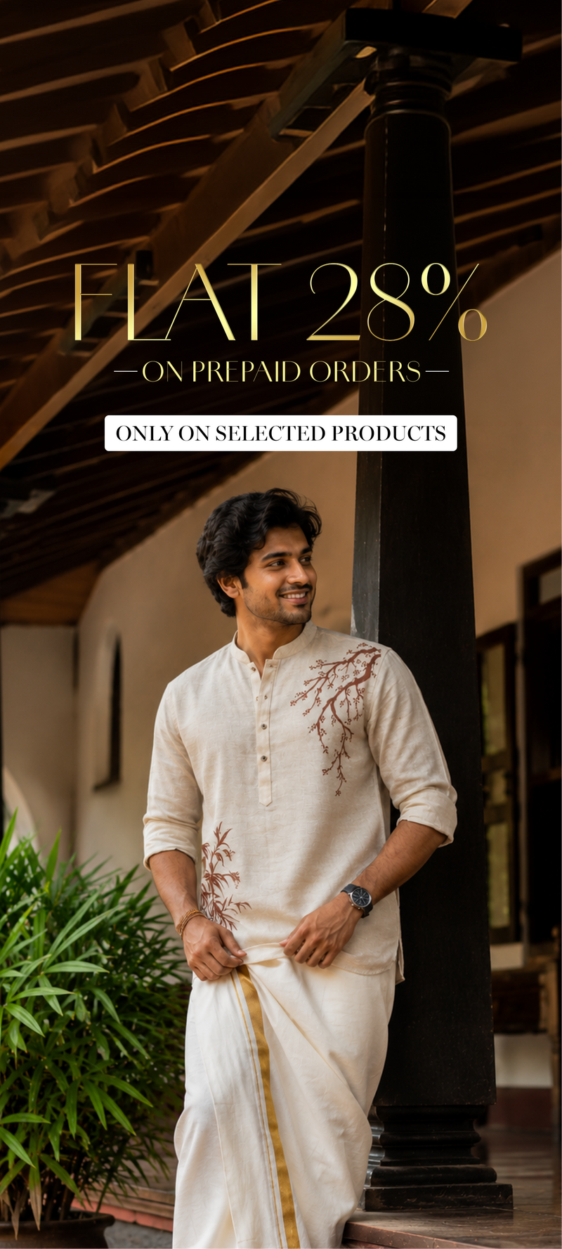 A man wearing a cream-colored traditional Indian kurta with brown floral embroidery and a matching drape, standing in a rustic corridor celebrating onam
